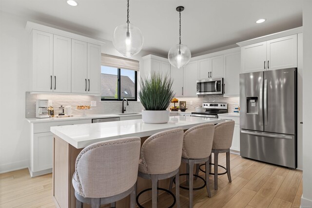 17447 Megan Dr, Macomb, MI 48042 - kitchen with appliances with stainless steel finishes, a sink, a center island, backsplash, and white cabinetry
