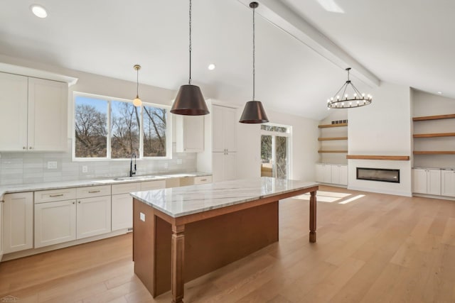 7474 Connies Dr, Shelby Twp, MI 48316 - kitchen featuring light wood-style flooring, vaulted ceiling with beams, plenty of natural light, and a sink