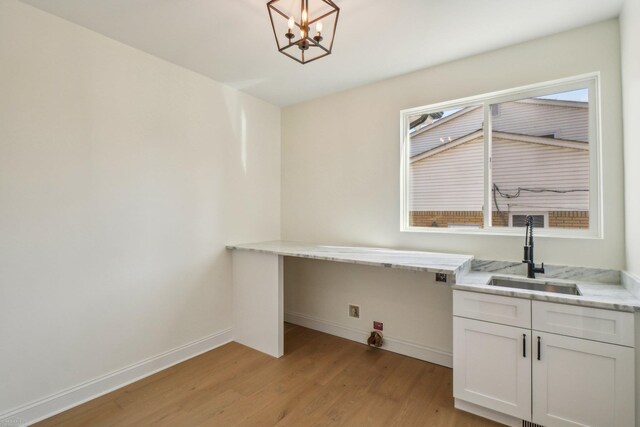 7474 Connies Dr, Shelby Twp, MI 48316 - laundry room featuring a notable chandelier, light wood-style flooring, a sink, cabinet space, and baseboards