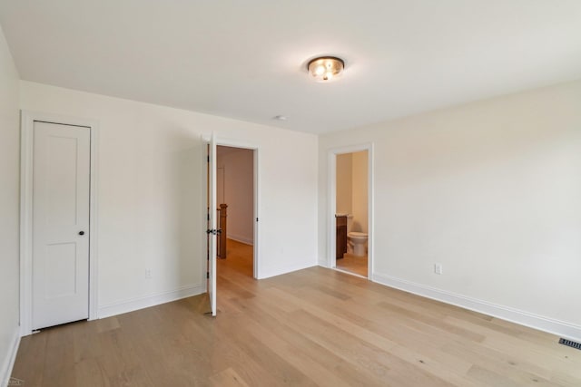 7474 Connies Dr, Shelby Twp, MI 48316 - unfurnished bedroom featuring light wood finished floors, ensuite bathroom, and baseboards