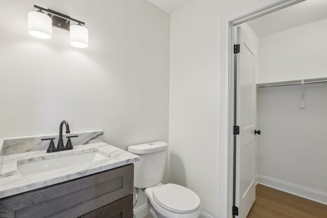 7474 Connies Dr, Shelby Twp, MI 48316 - half bathroom with baseboards, toilet, wood finished floors, and vanity