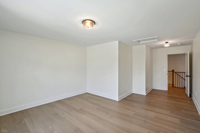 7474 Connies Dr, Shelby Twp, MI 48316 - spare room featuring attic access, light wood-type flooring, and baseboards