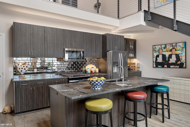 65 Sea Ray Blvd Unit 7, Harrison Twp, MI 48045 - kitchen with a sink, backsplash, stainless steel appliances, a breakfast bar area, and light wood finished floors