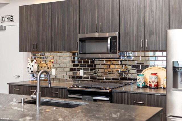 65 Sea Ray Blvd Unit 7, Harrison Twp, MI 48045 - kitchen with tasteful backsplash, dark brown cabinetry, dark stone countertops, stainless steel appliances, and a sink