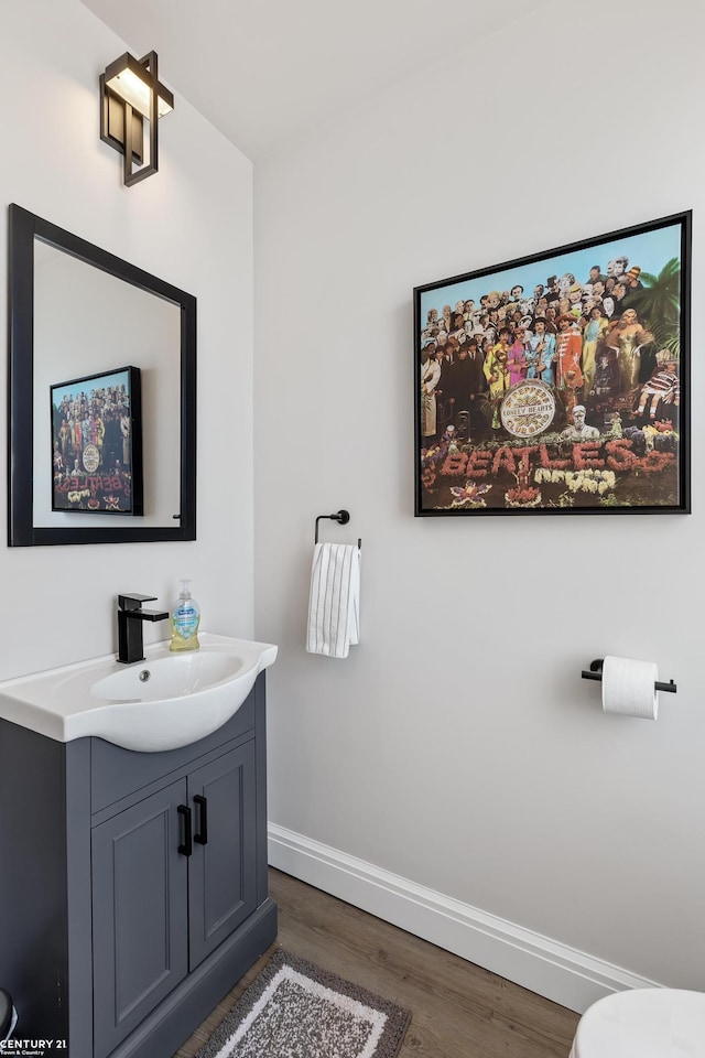 65 Sea Ray Blvd Unit 7, Harrison Twp, MI 48045 - half bathroom with baseboards, toilet, wood finished floors, and vanity