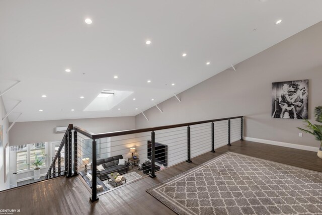 65 Sea Ray Blvd Unit 7, Harrison Twp, MI 48045 - workout area featuring lofted ceiling with skylight, a wall unit AC, wood finished floors, and baseboards
