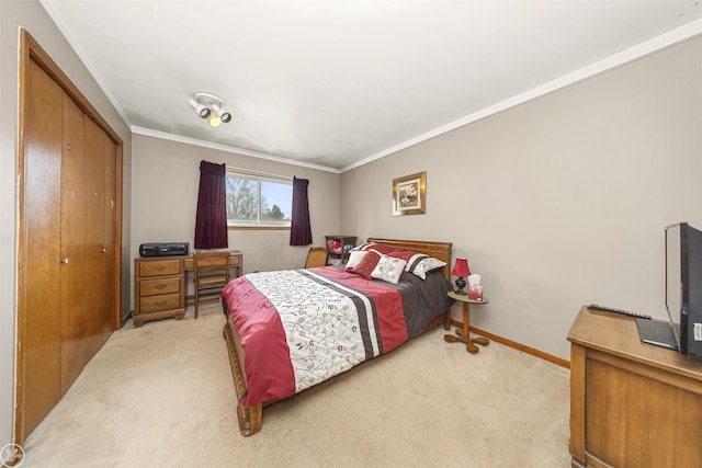bedroom featuring a closet, light carpet, crown molding, and baseboards