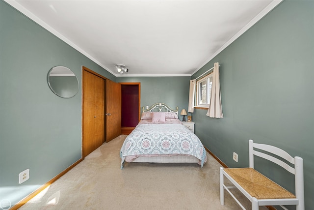 carpeted bedroom with baseboards, a closet, and ornamental molding