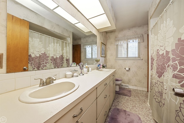 bathroom featuring wallpapered walls, visible vents, toilet, and a sink