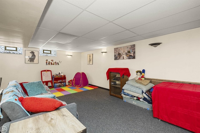 carpeted living area with a paneled ceiling