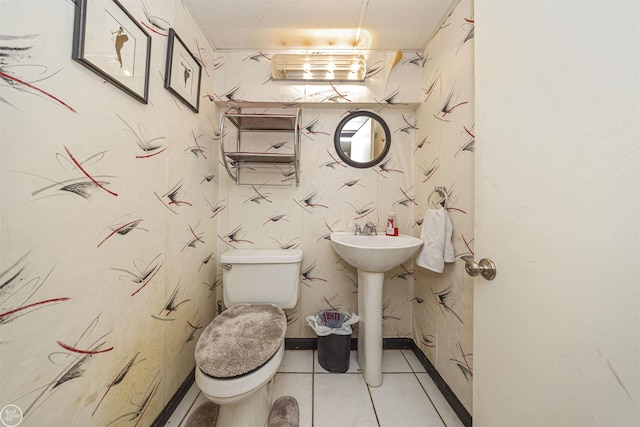 bathroom featuring toilet, tile patterned floors, and baseboards