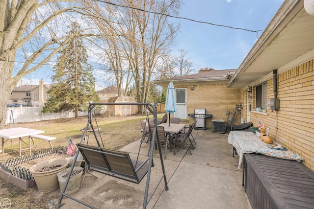 view of patio featuring a fenced backyard, grilling area, outdoor dining area, and central AC unit