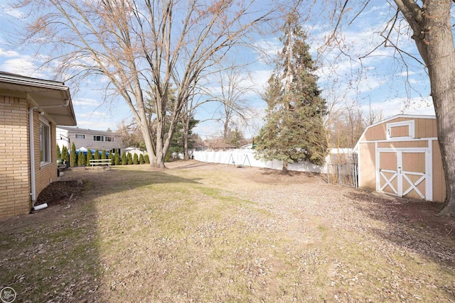 view of yard with a storage unit, an outdoor structure, and fence