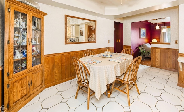 dining area with wood walls, wainscoting, and light floors