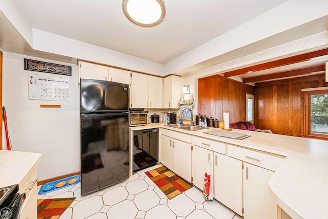 kitchen featuring freestanding refrigerator, light countertops, a sink, and white cabinets