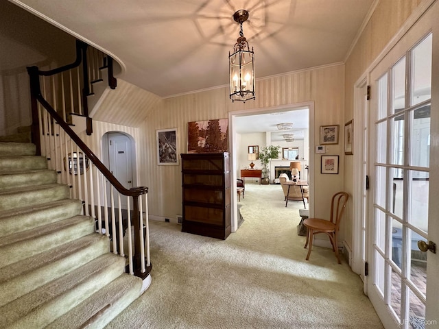 foyer entrance with baseboards, carpet flooring, stairway, and crown molding