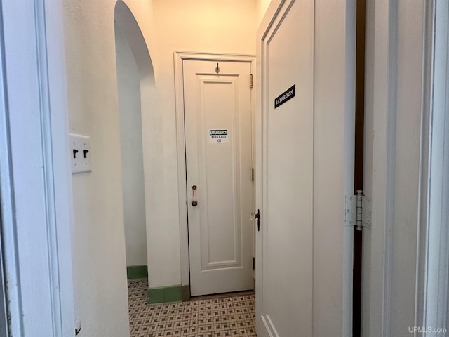 hall featuring tile patterned floors and arched walkways
