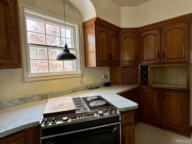 kitchen featuring range, light countertops, brown cabinetry, and light floors
