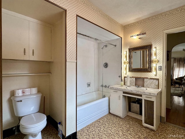 full bathroom featuring wallpapered walls, toilet, and shower / tub combination