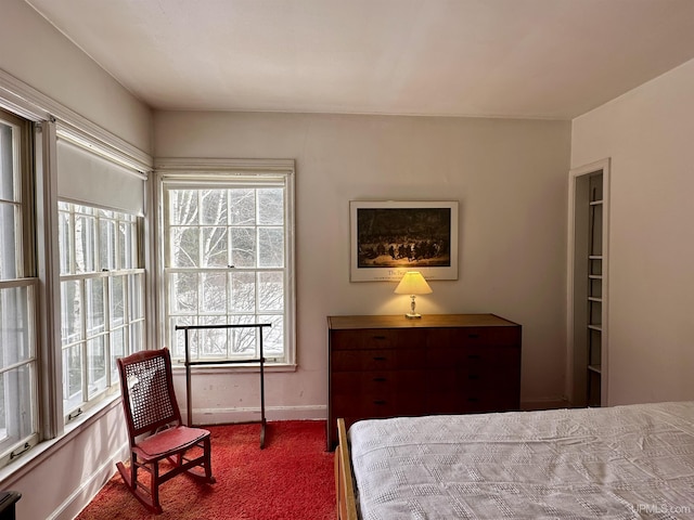 bedroom with baseboards and dark colored carpet
