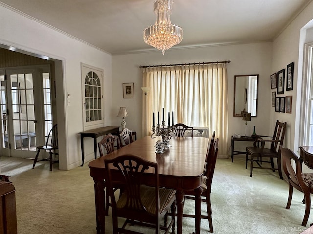 dining space with light colored carpet, crown molding, and a chandelier