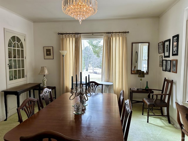 dining space with crown molding, carpet floors, and a chandelier