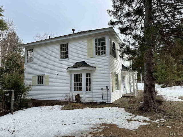 view of snow covered rear of property