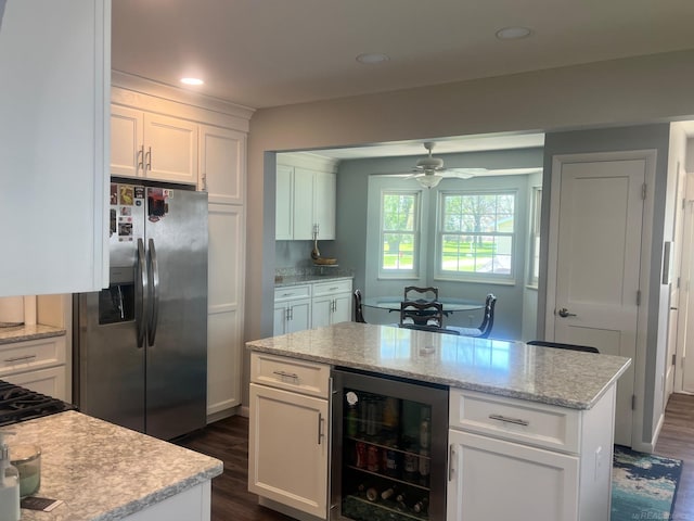 kitchen with stainless steel fridge, beverage cooler, a ceiling fan, dark wood-style flooring, and white cabinetry