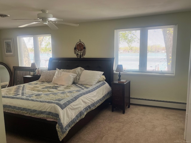 bedroom featuring baseboard heating, light carpet, and ceiling fan