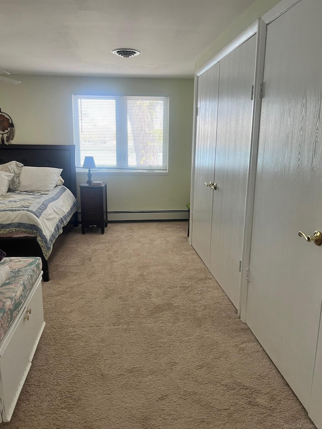 bedroom with carpet flooring, a baseboard radiator, and a closet