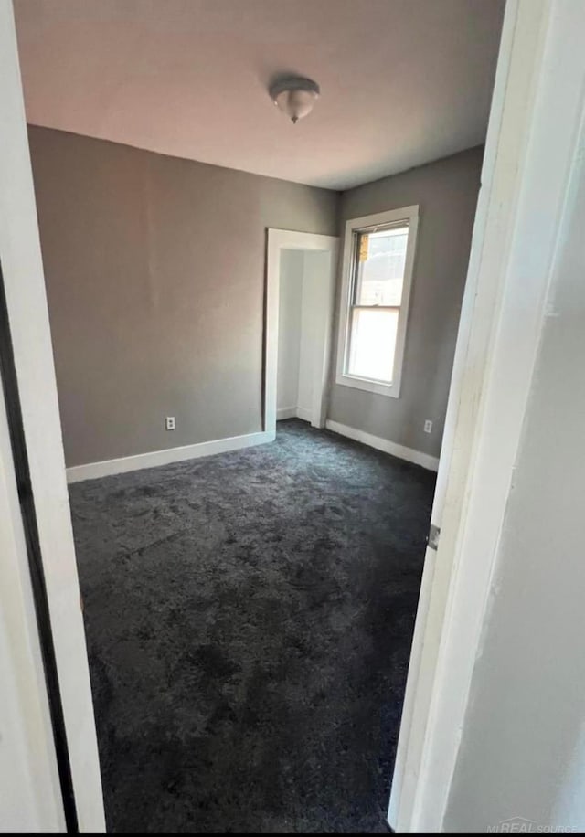 4716 Garland St, Detroit, MI 48214 - unfurnished bedroom featuring baseboards and dark carpet