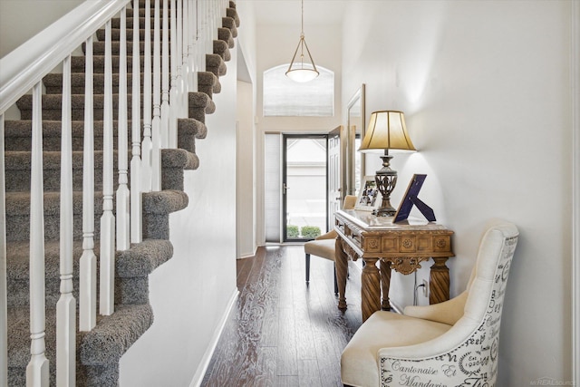 foyer entrance with stairs, baseboards, and wood-type flooring