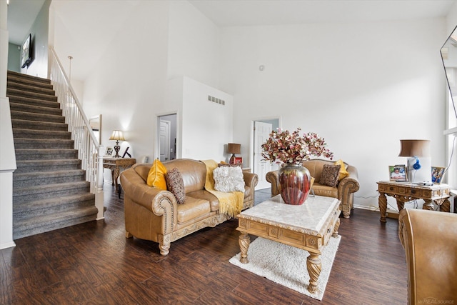 living room with stairs, visible vents, and dark wood-style floors