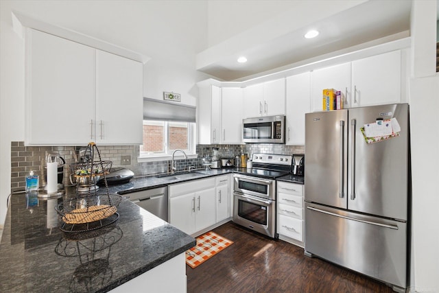 kitchen with backsplash, a sink, dark wood finished floors, stainless steel appliances, and white cabinets