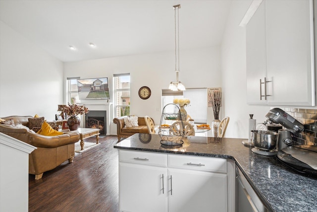 kitchen with a peninsula, open floor plan, white cabinets, decorative backsplash, and dark wood-style flooring
