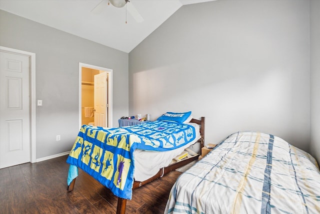 bedroom featuring vaulted ceiling, wood finished floors, ensuite bathroom, baseboards, and ceiling fan