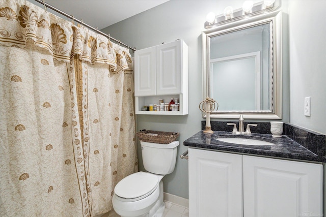 bathroom with toilet, vanity, tile patterned flooring, and baseboards