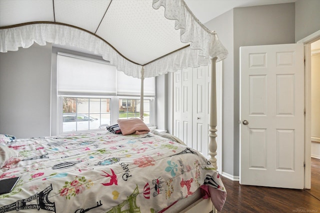bedroom featuring baseboards, vaulted ceiling, and dark wood finished floors