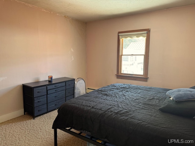 bedroom with light carpet, baseboards, and baseboard heating