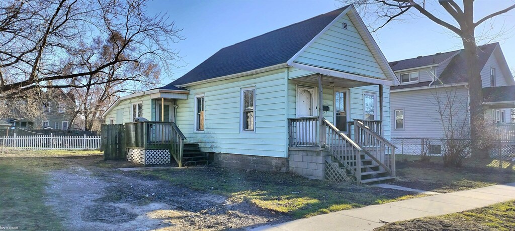 1036 Gillett St, Port Huron, MI 48051 - view of front facade featuring a shingled roof and fence