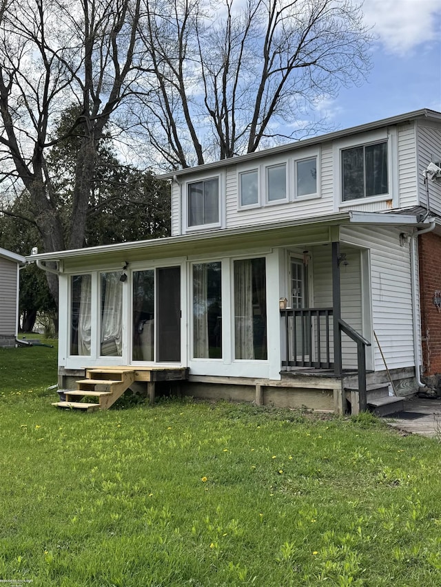 back of property featuring a sunroom, a porch, and a yard
