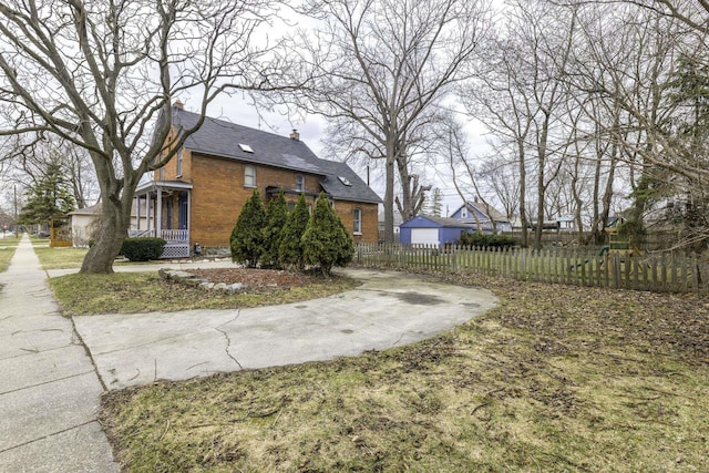 view of side of home with brick siding, fence, and a chimney
