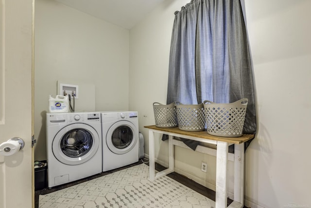 clothes washing area featuring washer and clothes dryer, baseboards, and laundry area