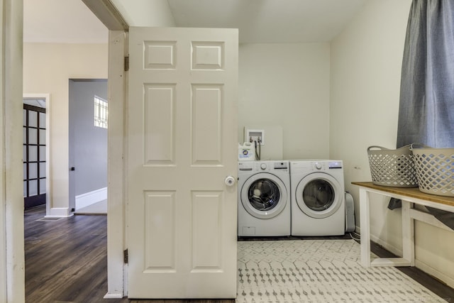 laundry room featuring separate washer and dryer, baseboards, laundry area, and wood finished floors