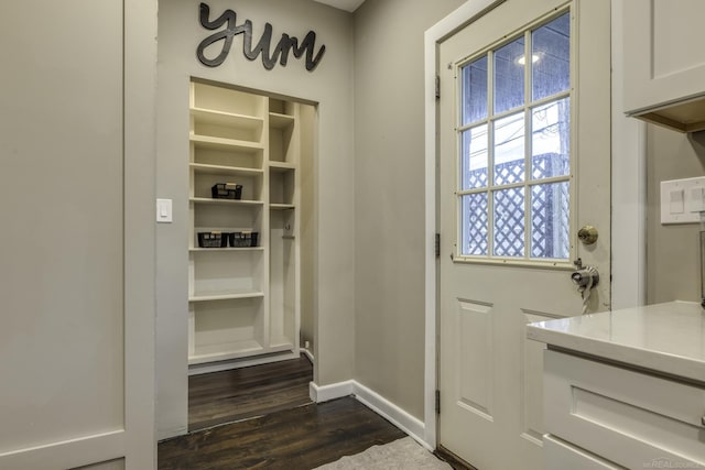 doorway to outside with dark wood-style floors and baseboards