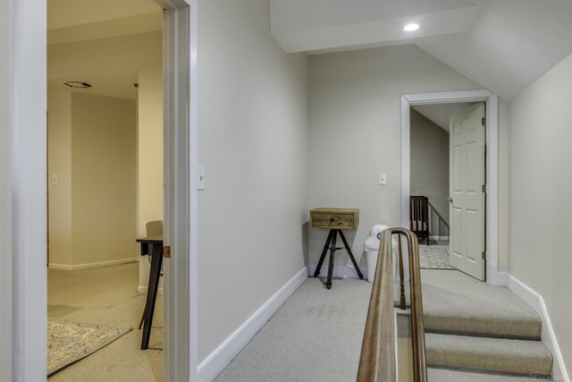 hall featuring light carpet, baseboards, lofted ceiling, and recessed lighting