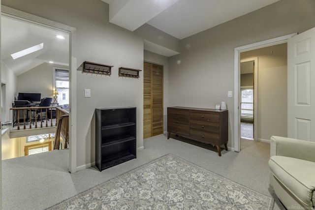 interior space featuring vaulted ceiling with skylight and baseboards