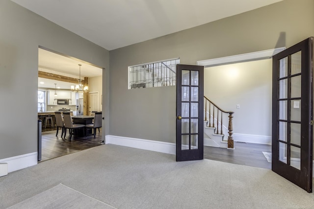 interior space featuring stairs, french doors, a chandelier, dark colored carpet, and baseboards