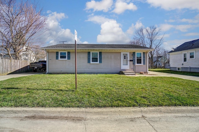 ranch-style house featuring a front yard, entry steps, fence, and driveway