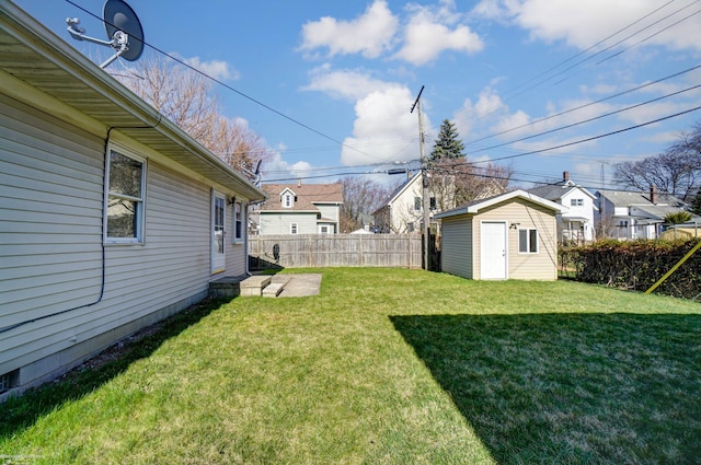 view of yard featuring a storage unit, a residential view, an outdoor structure, and fence